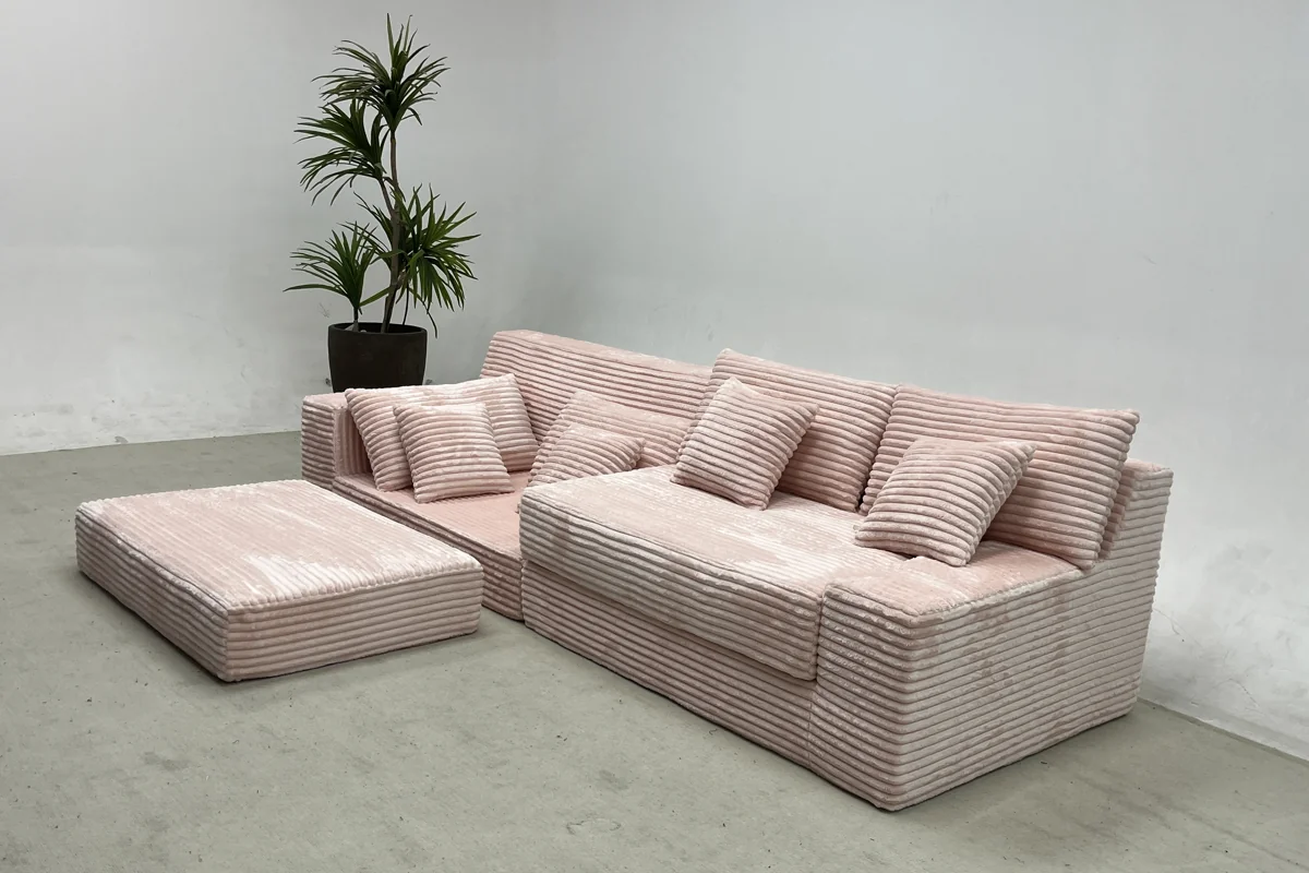 Pink sofa sections and separate ottoman in a product display